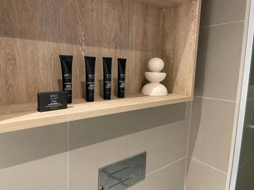 a shelf in a bathroom with some vases on it at Serenity Stayz - 3 Bedroom Apartment in Melbourne CBD in Melbourne
