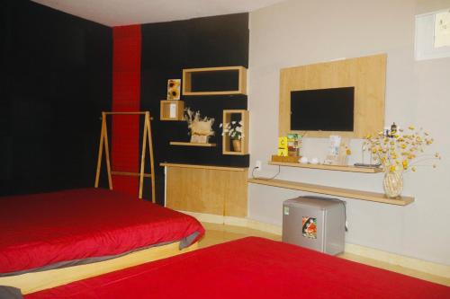 um quarto com duas camas e uma televisão e um tapete vermelho em KND Golden Hills Phúc Đà Lạt em Da Lat