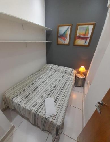 Dormitorio pequeño con cama y lámpara en Rio Praia, en Río de Janeiro