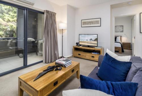 a living room with a couch and a tv at Domain 27 Apartment - Barton in Kingston 