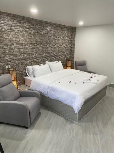um quarto com uma cama grande e uma cadeira em My Home em Patong Beach