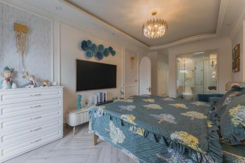 a bedroom with a bed and a dresser and a tv at Broccoli's House (Súp Lơ House) in Da Lat