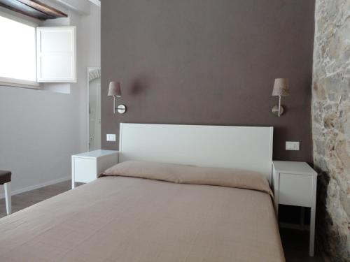 RotondellaにあるIl Giglio Casa Albergoのベッドルーム1室(白いベッド1台、ナイトスタンド2台付)