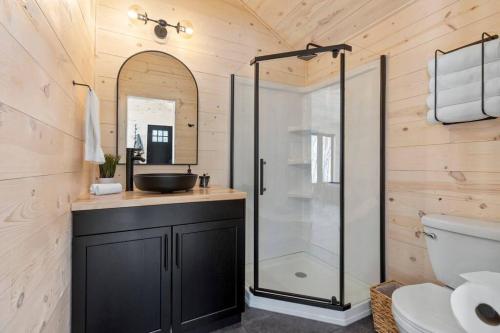 bagno con doccia in vetro e lavandino di *Tiny House Luxury Getaway: Solo Stove, Adventure* 