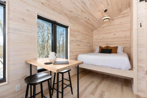 a bedroom in a tiny house with a bed and a desk at *Tiny House Luxury Getaway: Solo Stove, Adventure* in Ironton