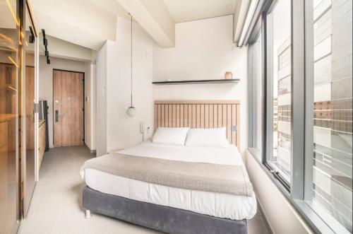 1 dormitorio con cama y ventana grande en LUXURY LOFT IN AMAZING BUILDING + POOL, en Bogotá