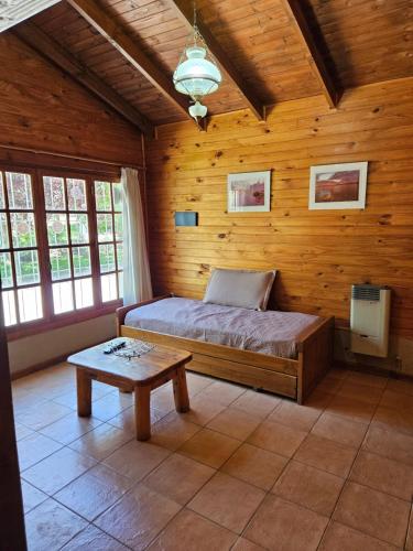 a bedroom with a bed and a table in it at Alerce Bariloche in San Carlos de Bariloche