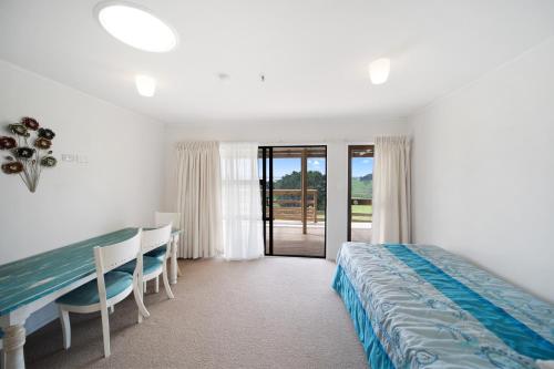 a bedroom with a bed and a table and chairs at Apartment 1 in Auckland