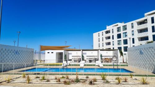 a swimming pool in front of a large building at Bello departamento en Bahia Inglesa con wifi y acceso quincho in Bahia Inglesa