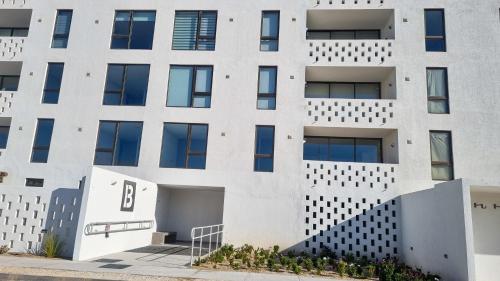 an apartment building with a white facade at Bello departamento en Bahia Inglesa con wifi y acceso quincho in Bahia Inglesa