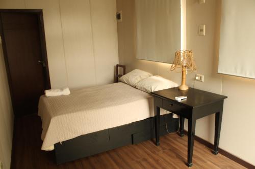 a bedroom with a bed and a table with a lamp at Relajate y disfruta in Santa Cruz de la Sierra