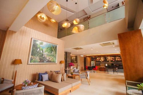 a large living room with a couch and chairs at Kuta Majesty Hotel in Legian