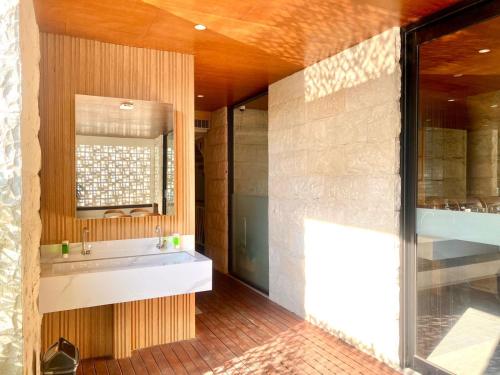 a bathroom with a sink and a mirror at Kuta Majesty Hotel in Legian