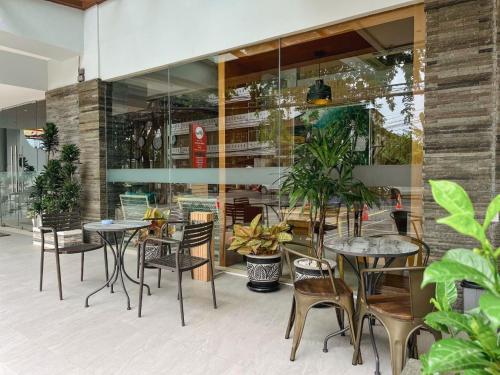 a restaurant with tables and chairs in front of a building at Kuta Majesty Hotel in Legian
