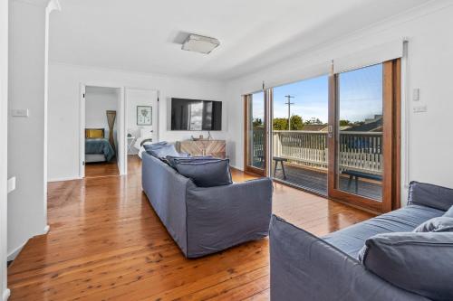 a living room with two couches and a balcony at Shoal Heaven in Shoalhaven Heads