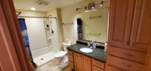 La salle de bains est pourvue d'un lavabo, de toilettes et d'un miroir. dans l'établissement Beautiful 4+ bed 3 bath Condo 20 minutes to Madison, 