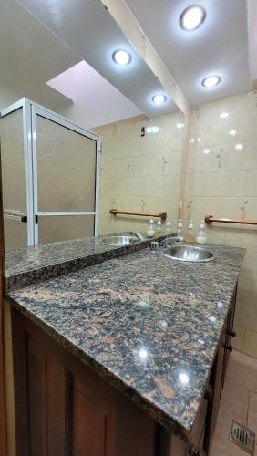 baño con 2 lavabos y encimera de granito en Casa Villa del Dique en Villa del Dique