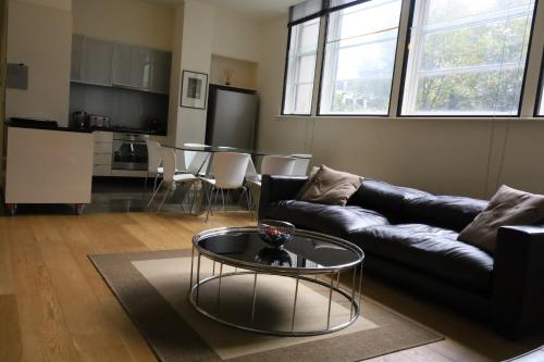 ein Wohnzimmer mit einem Sofa und einem Tisch in der Unterkunft The Walkup Southbank in Melbourne