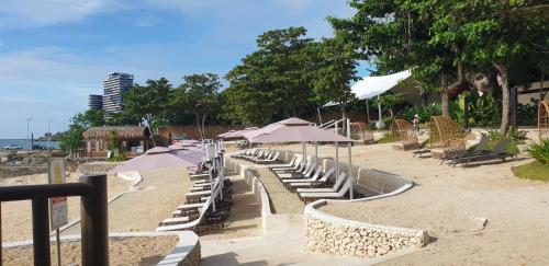 a row of chairs and umbrellas on a beach at One Pacific Residence Condominium Tower C-16N in Mactan