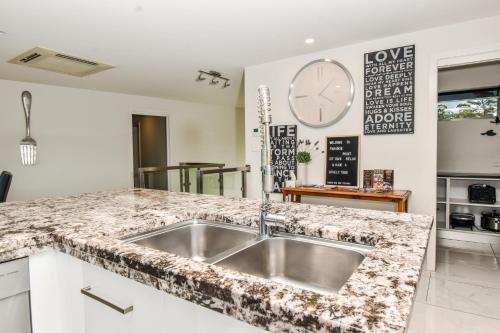 Clarence PointにあるParadise Point - Entire home in Clarence Point, Tasmania Australia, 10 guests 7 bedrooms 7 beds 3 bathsのシンクとカウンタートップのあるキッチン