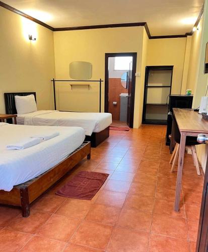 a room with two beds and a table and a desk at Nice view guesthouse in Vang Vieng