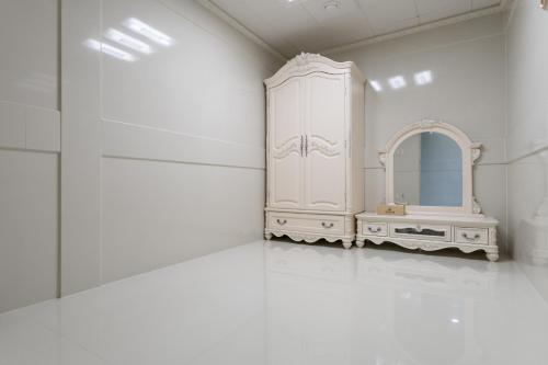 Baño blanco con tocador y espejo en Hotel Gaya, en Songju