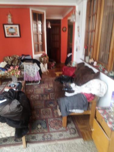 un soggiorno con pareti rosse e un divano di Casa Ballesteros Rodríguez a Oruro