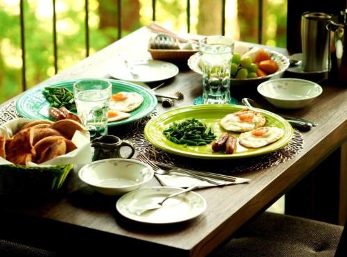 a wooden table with plates of food on it at Gableview Forest Inn ゲーブルビュー in Nikko