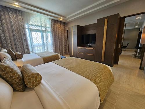 a hotel room with two beds and a television at LeoPalace Resort Guam in Yona