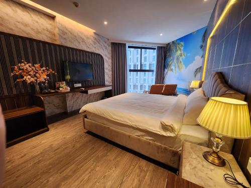 ein Schlafzimmer mit einem großen Bett und einem TV in der Unterkunft Apec Mandala Mũi Né Condotel By Vũ in Mui Ne