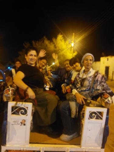 a group of people sitting on the back of a truck at malindy KA ماليندى كا in Aswan