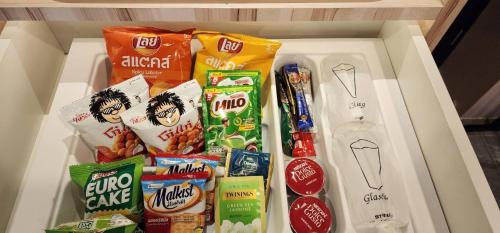 a white drawer filled with different types of snacks at The Room Boutique Hotel in Sakon Nakhon