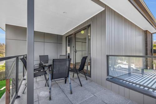 a balcony with chairs and a table on a house at Heather Merimbula in Merimbula
