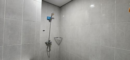 a shower with a hose in a bathroom at Apartemen Menara One Surakarta by Cariapartemen-id in Sukoharjo