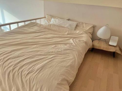 1 cama blanca grande con lámpara y mesa en Cheese Stay en Daegu