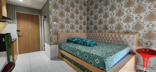 a bedroom with a bed with a green comforter at Apartemen Menara One Surakarta by Cariapartemen-id in Sukoharjo