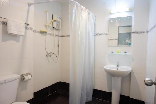 ein Bad mit einem Waschbecken, einem WC und einer Dusche in der Unterkunft The Corner in Patong Beach