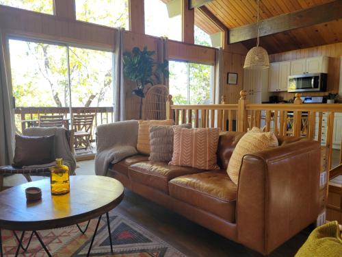 sala de estar con sofá marrón y mesa en Cresta Lunar- Cozy and Modern 2 Bedroom Cabin, en Big Bear Lake
