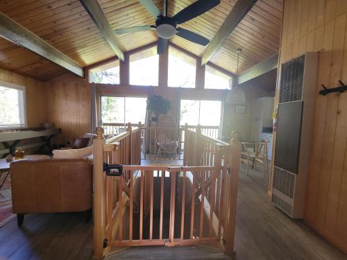 sala de estar con ventilador de techo y escalera en Cresta Lunar- Cozy and Modern 2 Bedroom Cabin, en Big Bear Lake
