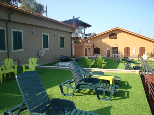 een tuin met stoelen en tafels en een huis bij Le Dimore di Chiara in Imperia