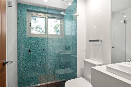 a bathroom with a shower and a toilet and a sink at Seagull in Mollymook