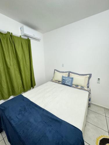 - une chambre avec un grand lit et un rideau vert dans l'établissement Linda casa para temporada, 450mts da praia, perto do aero porto, Beto Carreiro, Balneário Camboriú, com amplo terreno na frete e atra, à Navegantes