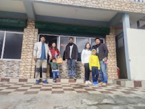 un grupo de personas de pie en frente de un edificio en Yangsel Lodge Tawang en Tawang