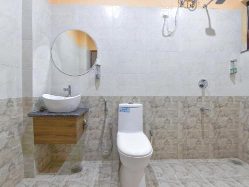 W łazience znajduje się toaleta, umywalka i lustro. w obiekcie Hotel Vibha Palace w mieście Dżajpur