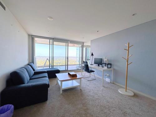 ein Wohnzimmer mit einem Sofa, einem Tisch und einem Schreibtisch in der Unterkunft Share House Master Room Near Chatswood Station in Sydney