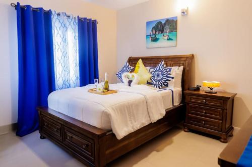 ルーシーにあるWelcome to our Ocean View Villa!のベッドルーム1室(青いカーテン付きの大型ベッド1台付)