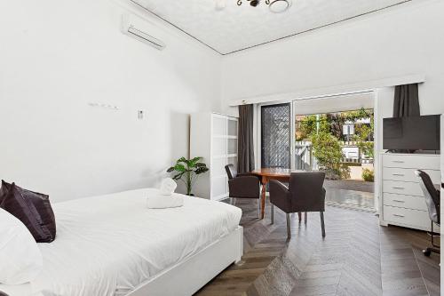 - une chambre avec un lit et une salle à manger avec une table dans l'établissement Stroll To Fremantle's Core Studio Apartment, à Fremantle