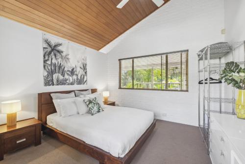 1 dormitorio con cama y ventana en Diggers Beach Surf House en Coffs Harbour