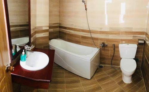 y baño con bañera, aseo y lavamanos. en Win Hotel - 43 Đường số 10, KDC Trung Sơn, Bình Chánh- by Bay Luxury en Ho Chi Minh