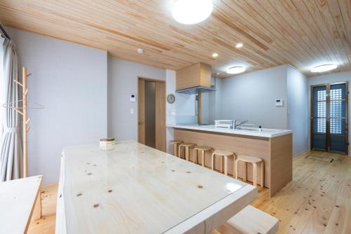 cocina con techo de madera y mesa de madera en Hinoki house en Fukuoka